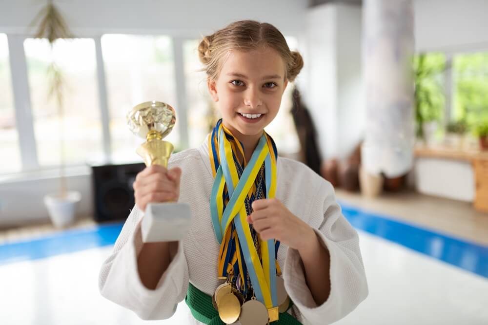 happy-talented-girl-practicing-aikido-showing-her-awards (1)